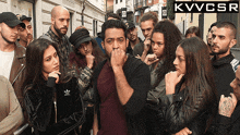 a group of people standing in front of a sign that says kvvcsr on it