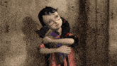 a little girl with glasses is hugging a stuffed animal