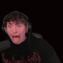 a man wearing headphones is making a funny face while talking into a microphone .