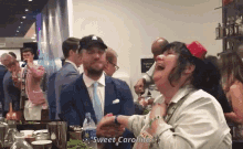 a woman laughs while holding a man 's hand with the words sweet caroline written on the bottom