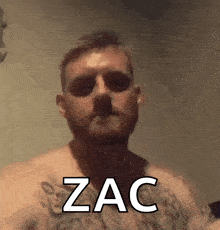 a shirtless man with a tattoo on his chest has the word zac on his face