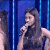 a woman is holding a microphone in her mouth and talking into it .