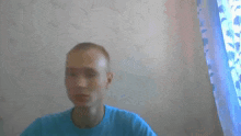 a blurry picture of a man in a blue shirt in front of a window