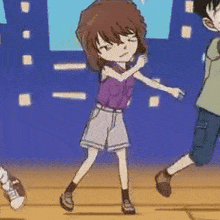 a girl in a purple shirt and shorts is dancing with a boy