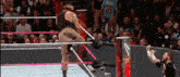 a wrestler is kicking another wrestler in the ring .