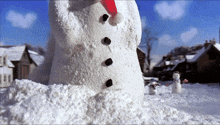 a snowman wearing a santa hat stands in a pile of snow