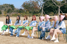 a group of girls are sitting in chairs in a field wearing adidas shoes