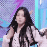 a girl with long black hair is dancing on a stage .