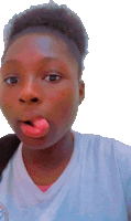 a young girl sticking her tongue out while wearing a white shirt with a logo on it