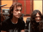 a man with long hair is wearing a black shirt that says ' i love you ' on the front