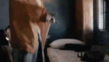 a person is standing next to a bed in a dark room .