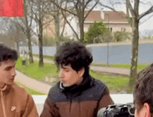 a man wearing a nike jacket is taking a picture of two other men