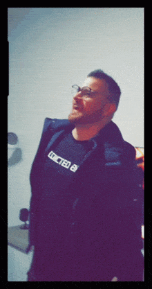 a man wearing glasses and a shirt that says addicted b