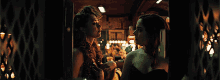 a couple of women standing next to each other in a dark room