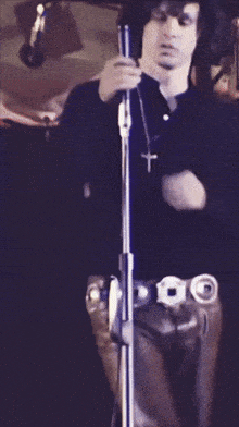 a man in a black shirt is holding a microphone in his right hand