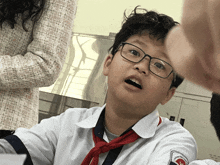 a boy wearing glasses and a red tie has a patch on his shirt that says " trung quoc " on it