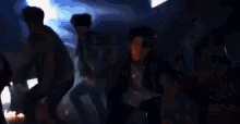 a group of people are dancing in a dark room in a club .
