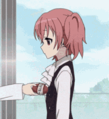 a girl with pink hair is being handed a football
