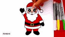 someone is drawing santa claus with sharpie markers in the background