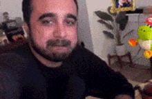 a man with a beard is sitting in front of a stuffed animal .