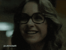 a close up of a woman wearing glasses and smiling