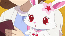 a girl holding a white rabbit with a pink flower on its head
