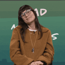 a woman wearing glasses is standing in front of a chalkboard that says mad
