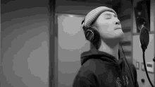 a man wearing headphones is singing into a microphone .