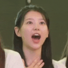 a woman is making a funny face with her mouth open .