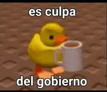 a yellow rubber duck is holding a cup of coffee and saying `` es culpa del gobierno '' .