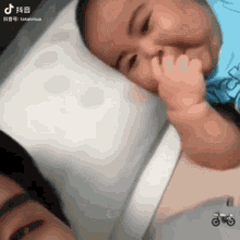 a baby laying on a pillow with a motorcycle in the foreground