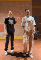two people are dancing in a hallway and one has a t-shirt that says геис