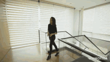a woman is walking down a set of stairs with the words made in animatica below her