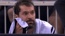 a man with a towel wrapped around his neck looks at something