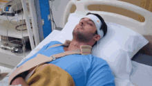 a man in a hospital bed has a bandage on his head