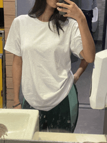 a woman is taking a selfie in a bathroom mirror