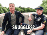 a man in a suit and a man in a red bull shirt are sitting on a boat and the caption says snuggles