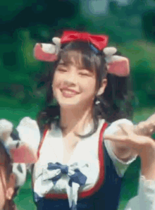 a girl is wearing a cow costume and smiling while standing in a field .