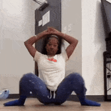 a woman is doing squats on the floor in a room .