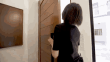 a woman standing in front of a wooden door