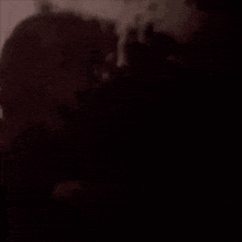 a man and a woman are dancing in a dark room in red light .