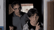 a man wearing glasses is standing next to a woman