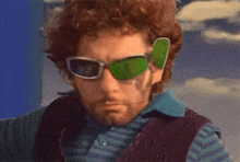 a man with a beard wearing green sunglasses