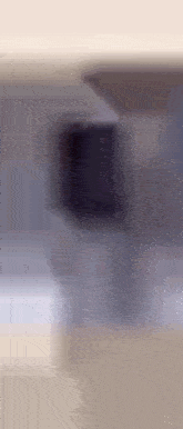 a blurry picture of a person standing in front of a building with a blurred background .