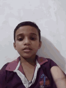 a young boy wearing a purple shirt with the word lg on it