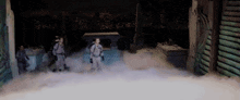 a group of people are standing in a room with smoke coming out of the door .