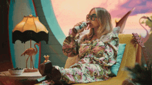 a woman sitting on a couch drinking from a bottle that says ' coca cola ' on it