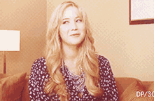 a woman with blonde hair is sitting on a couch with dp / 30 written on the bottom