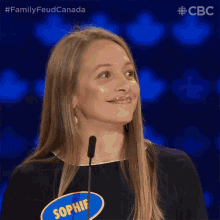 a woman stands in front of a microphone with a name tag that says sophie on it