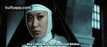 a nun is standing in a dark room and says `` don t mess with me , hysterical bitches . ''